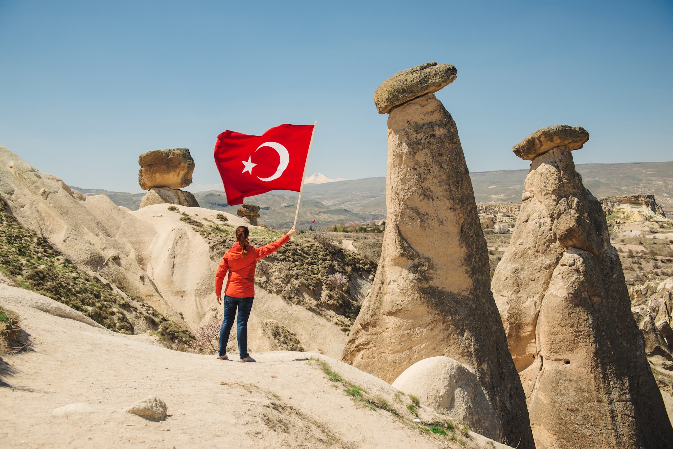 Vrouw houdt turkse vlag in de lucht in Turkse natuur